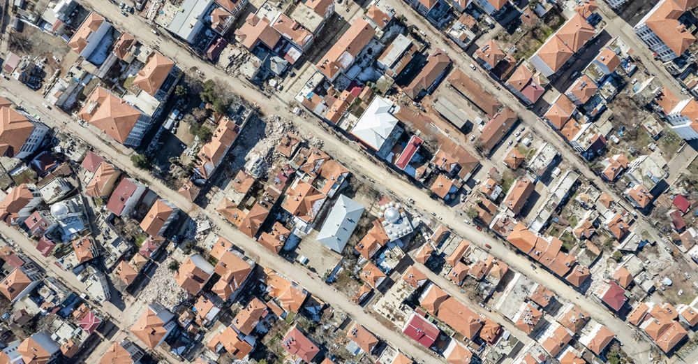 Luftaufnahme zerstörter Häuser und Straßen nach dem starken Erdbeben in der Südosttürkei 2023