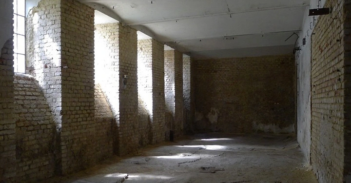 Galerie-Bild 1: Leere Ziegelsteinwände haben Lichtstrahlen durch Fensteröffnungen mit hohen Decken in einem großen verlassenen Verschlagraum filters das Licht auf den staubigen Boden.