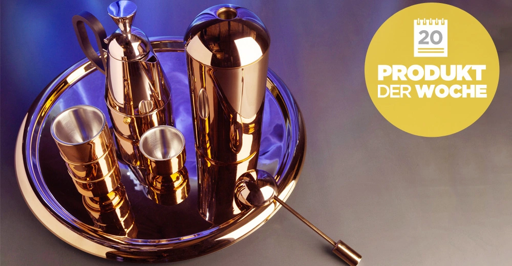 Ein Satz aus metallischen Getränkebehältern steht auf einem runden Tablett. Ein gelbes Symbol rechts zeigt den Text 20 PRODUKT DER WOCHE. Hintergrund blau-violett.