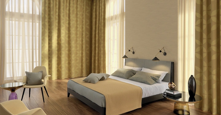 Galerie-Bild 12: Ein Bett steht in einem elegant eingerichteten Schlafzimmer mit Holzboden große Fenster mit gelben Vorhängen und zwei Stühlen daneben. Wandlampen hängen über dem Bett.