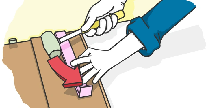 Zwei Hände bedient einen Hammer an einem Holzpaneel in einem Innenraum. Ein roter Pfeil zeigt auf das zu bearbeitende Holzstück.