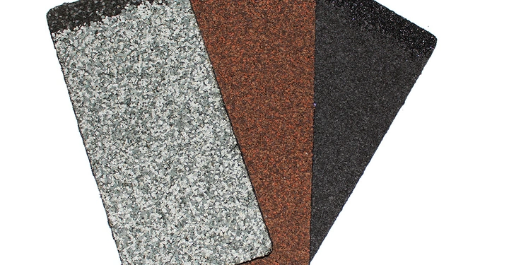 Drei rechteckige Schindeln in grau rot und schwarz liegen fächerartig angeordnet auf einer weißen Fläche.