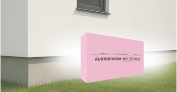 Darstellung der Austrotherm XPS® TOP Sockel Dämmplatte vor Hausfassade auf Gras