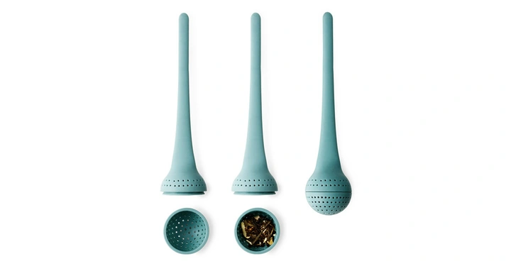 Drei türkisfarbene Teesiebe, eines geöffnet und teilweise gefüllt, auf einer weißen Oberfläche nebeneinander liegend.