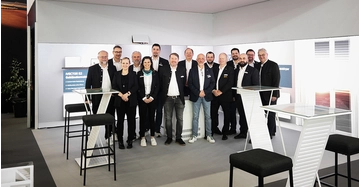 Das Team von Vogel&Noot im Messestand des Unternehmens lächelt in die Kamera.