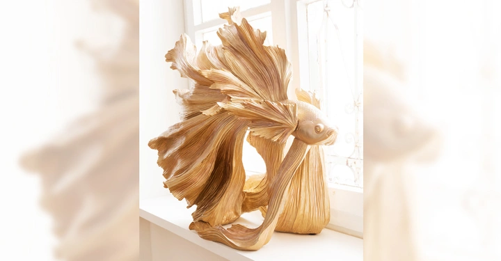 Galerie-Bild 9: Eine goldene Fischskulptur steht neben einem hellen Fenster zeigt dynamische Flossenbewegung in einem eleganten modernen Wohnraum.