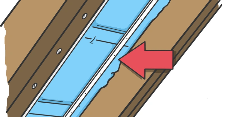 Rote Pfeil zeigt auf Nahtstelle eines blauen Blechs zwischen Holzverkleidungen in einer Hauswandansicht