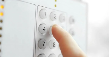 Hand drückt Tasten auf einem weißen Ziffernblock Tasten 1 2 4 7 zu sehen Hintergrund unscharf and hell