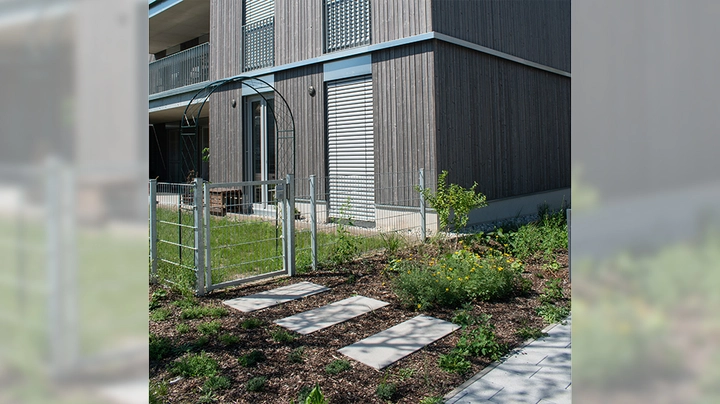 Galerie-Bild 5: längliche Rasensteine führen von gepflasterter Fläche über eine kleine Wiese in einen Garten.