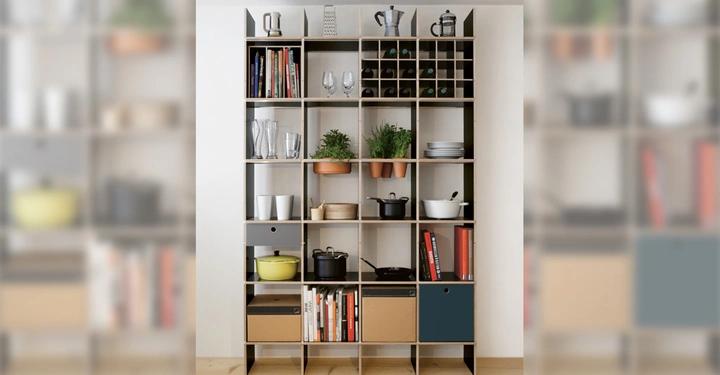 Galerie-Bild 5: Regal steht an der weißen Wand enthält Bücher Geschirr Pflanzen und eine Kaffeekanne kleiner Holzkasten und bunte Boxen auf Holzfußboden in einem modernen Raum.