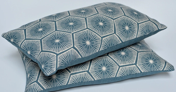 Galerie-Bild 2: Zwei übereinander liegende Kissen mit blau-weißen geometrischen Mustern in einem hellen Raum.