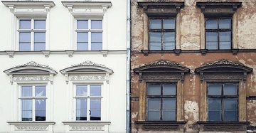 Frontalansicht einer historischen Häuserfront. Eine Seite ist saniert, die andere alt und baufällig.