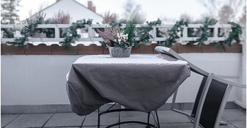 Terrassentisch und angelehnter Sessel, beides Schnee bezuckert