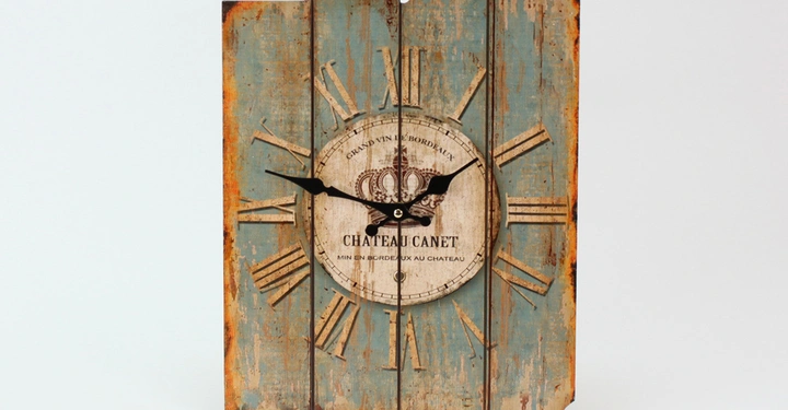 Galerie-Bild 9: Eine rustikale Holzuhr zeigt schwarze Zeiger und römische Ziffern in einer abgenutzten optik. Text in der Mitte lautet Grand Vin de Bordeaux Château Canet Vin en Bouteille au Château.