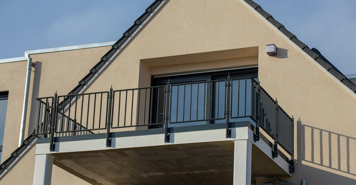 Galerie-Bild 2: Vorsatzbalkon mit schwarzem Geländer an einem modernen Mehrfamilienhaus