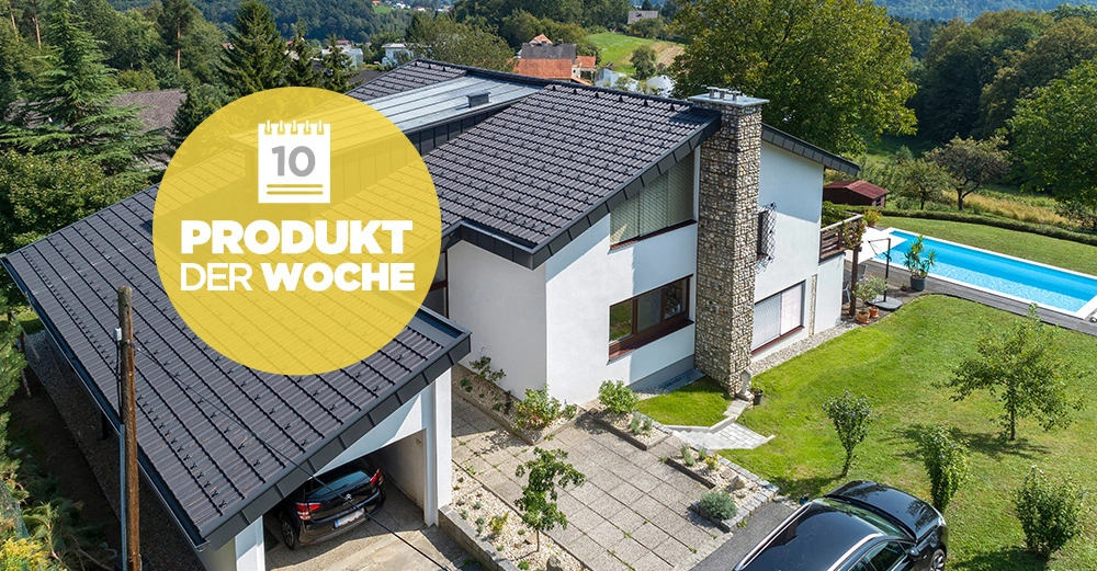 Ein modernes weißes Haus mit dunklem Dach und Steinverkleidung steht in einem grünen Garten mit Pool und Bäumen Vor dem Haus steht ein schwarzes Auto Gelber Kreis mit Text PRODUKT DER WOCHE
