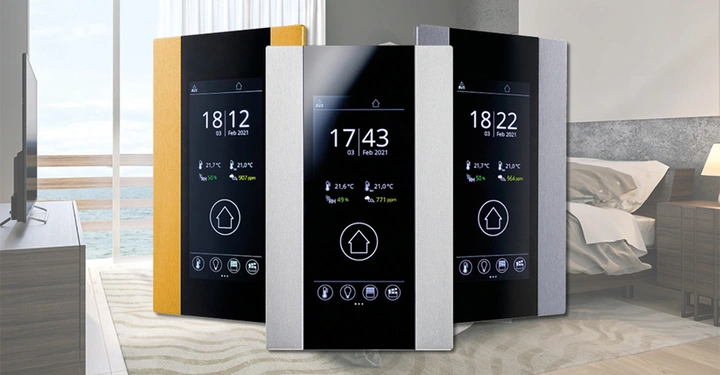 Drei digitale Steuergeräte zeigen Informationen wie Datum 03 Feb 2021 aktuelle Temperatur 21.7°C und Uhrzeit in einem modernen Schlafzimmer mit Blick auf ein Holzdeck mit Ozean im Hintergrund.