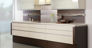 Der Küchenschrank steht still in einer modernen Küche mit großen Schubladen und Schränken in weiß und dunkelbraun vor einer glatten Wand und glänzendem Boden.