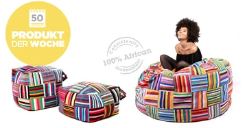 Eine junge Frau sitzt auf einem bunten Sitzsack und lächelt auf einem weißen Hintergrund. Links sind zwei kleinere bunte Sitzsäcke. Text in der Grafik 50 PRODUKT DER WOCHE consistently 100% African inconsistent.
