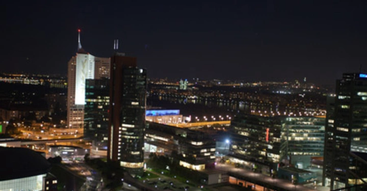 Galerie-Bild 71: Beleuchtete Hochhäuser bei Nacht Innenstadt großstädtische Lichter und Gebäude umgeben die Wolkenkratzer helle Fenster strahlen in das dunkle Stadtbild Fluss und horizontale Lichter im Hintergrund sichtbar