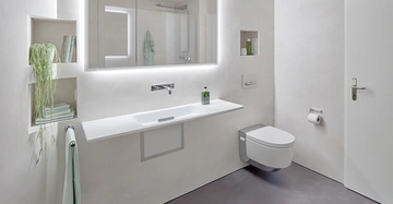 Ein weißes Badezimmer mit schwebendem Waschbecken und wandhängender Toilette in einer modernen, minimalistischen Umgebung. Handtuchhalter, Regale mit Pflanzen und Pflegeprodukten links und rechts vorhanden.