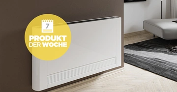 Ein weißer Heizkörper ist an einer braunen Wand montiert, daneben liegt ein grau-schwarzer Teppich im Wohnzimmer. Text auf gelbem Kreis: 7 PRODUKT DER WOCHE