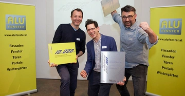 die Preisträger stehen jubelnd und mit in die Luft gereckten Fäusten vor gelben AFI Aufstellern. In den Händen die Preise und große Schecks über 10.000 Euro